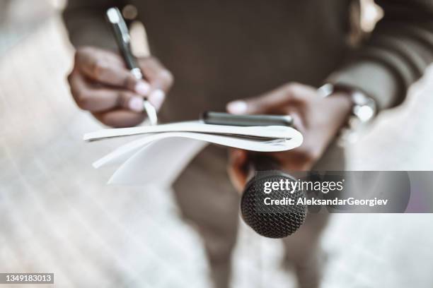 african male journalist preparing questions for press conference - jornalismo imagens e fotografias de stock