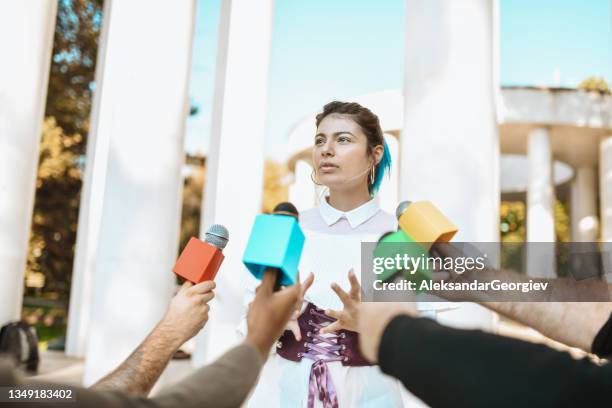 female alternative fashion icon leading press conference outside - journalist icon stock pictures, royalty-free photos & images