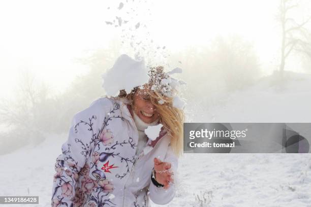 mother getting hit by a snowball - jong van hart stockfoto's en -beelden