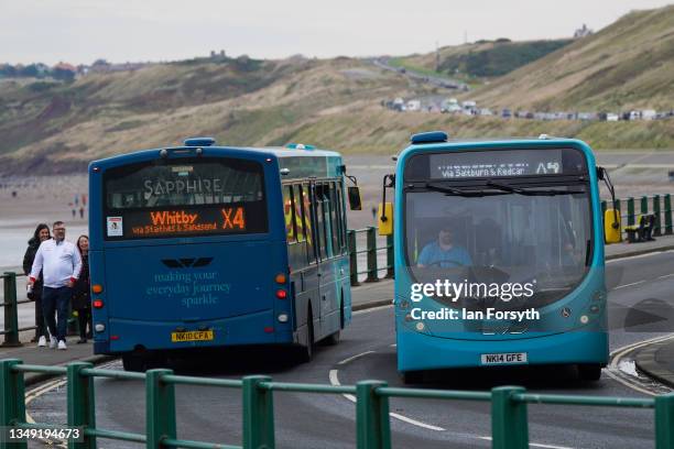 Two buses pass as they travel the route on the North Yorkshire coast between Saltburn By The Sea and Whitby on October 26, 2021 in Whitby, England....