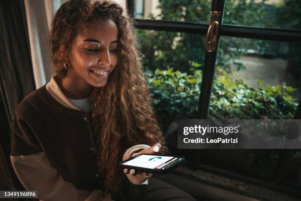 young generation z teenage girl checking her own investments on mobile - bank statement stock pictures, royalty-free photos & images