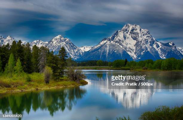 scenic view of lake by snowcapped mountains against sky,moran,wyoming,united states,usa - moran stockfoto's en -beelden
