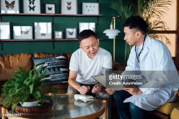 senior asian male patient having a conversation with a male doctor, discussing on his health concerns and giving professional advice during home visit. elderly and healthcare concept - diabetes pills stock pictures, royalty-free photos & images
