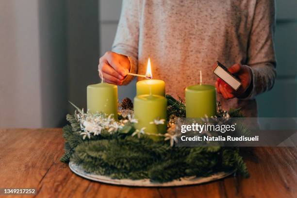 lighting the first candle on swiss advent wreath. - christmas candles stock-fotos und bilder