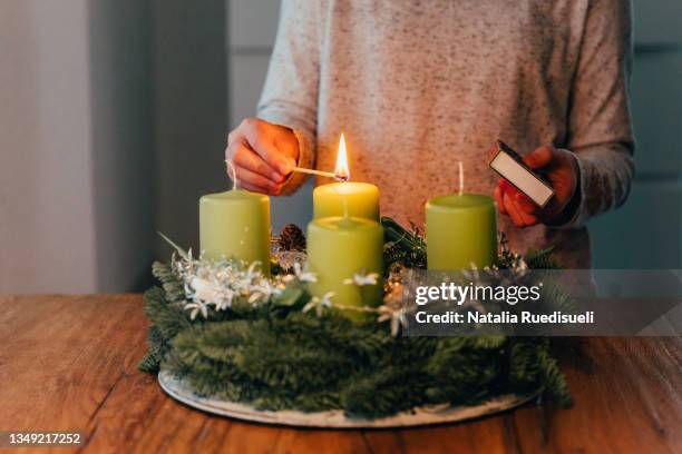 lighting the first candle on swiss advent wreath. - christmas candle stock pictures, royalty-free photos & images