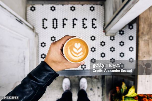 man drinking coffee at the coffee shop, personal perspective view - cappuccino top view stock-fotos und bilder