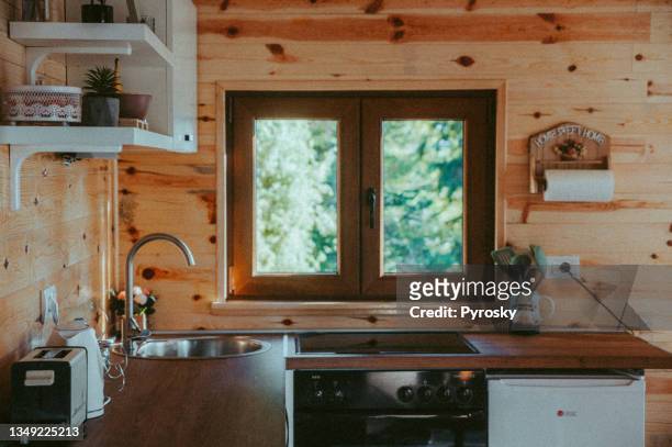 the interior design of a kitchen in a tiny rustic log cabin. - sunny kitchen stock pictures, royalty-free photos & images
