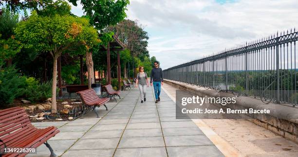 an adult man and woman strolling through a park in autumn. - valladolid spanish city stock-fotos und bilder