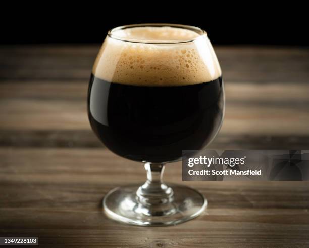 side view of a glass of dark beer - stoutbier stock-fotos und bilder