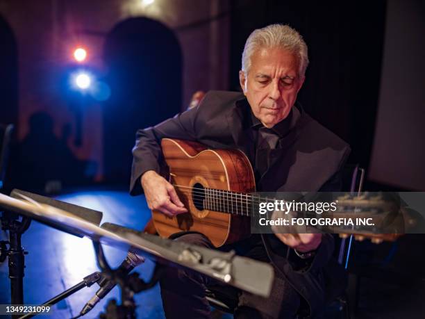 reifer männlicher gitarrist auf der bühne - fado stock-fotos und bilder