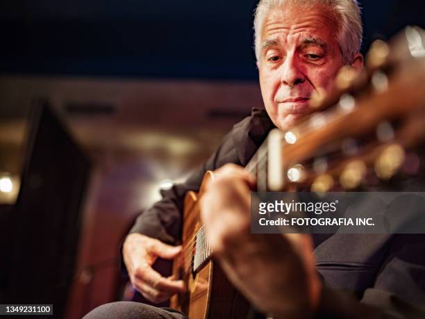 mature male guitarist on the stage - guitarist stockfoto's en -beelden