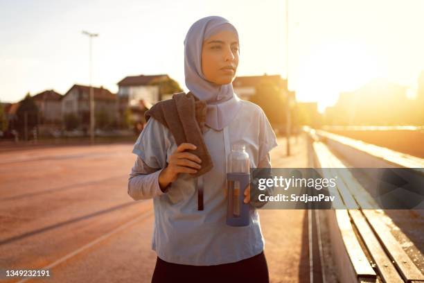 kaukasische athletin islamischen glaubens ruht sich nach intensivem training aus - arab culture stock-fotos und bilder