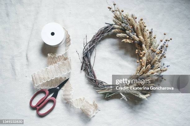 making a beautiful autumn wreath for the decor of an apartment or house from dried flowers. close-up - wreath making stock pictures, royalty-free photos & images