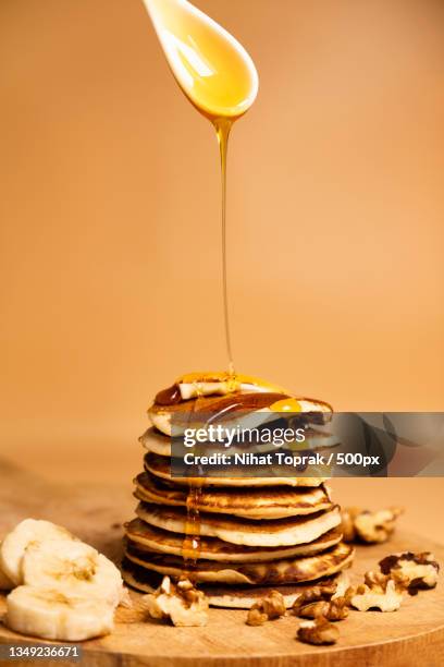close-up of honey poured on banana walnut pancakes - nihat stock pictures, royalty-free photos & images