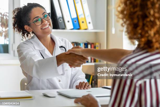 greeting with her doctor - doctors shaking hands stock pictures, royalty-free photos & images