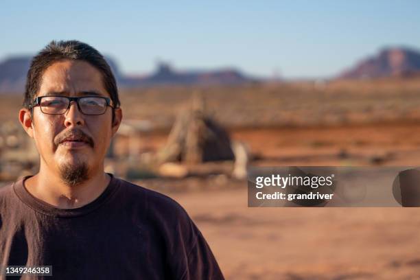 navajo young native american man landcape portrait in front of monument valley arizona with tracheotomy scar from being on a ventilator with coronavirus covid-19 - cherokee indian women stockfoto's en -beelden