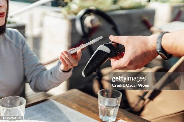 paying with mobile phone at restaurant - card reader stockfoto's en -beelden