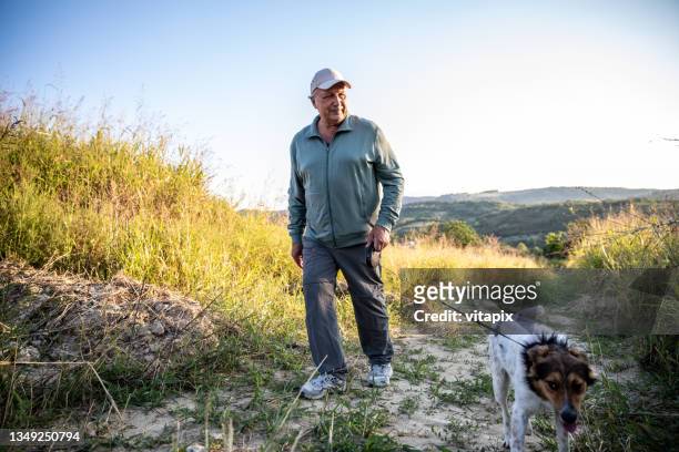 hombre disfrutando paseando a su perro - dog walking fotografías e imágenes de stock