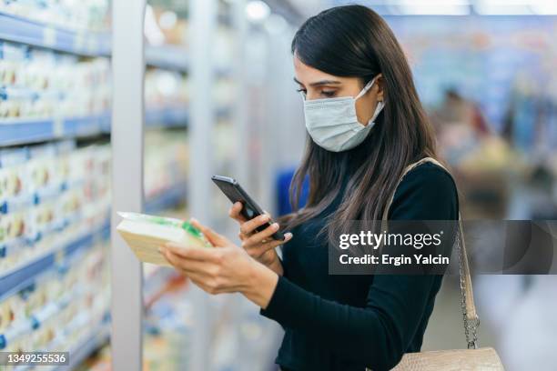 young woman scanning barcode with smartphone - scanner stock stockfoto's en -beelden