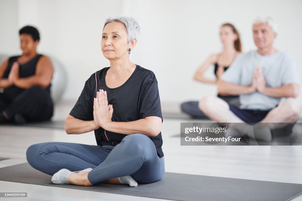 Mature woman doing yoga in class