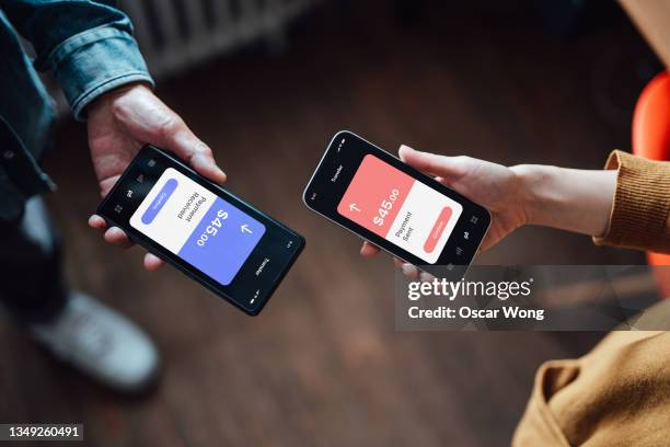 closeup of two people managing online banking with smart phone - person look up from above stock-fotos und bilder