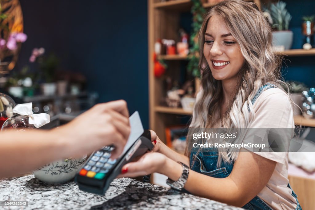 Customer making wireless or contactless payment using credit card.