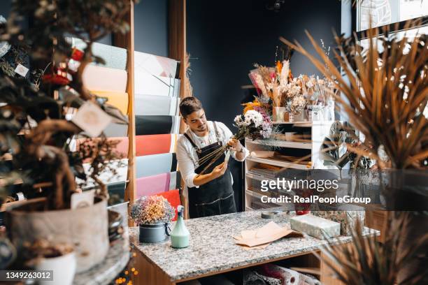 portrait of happy florist man working at his flower shop - apron stock pictures, royalty-free photos & images