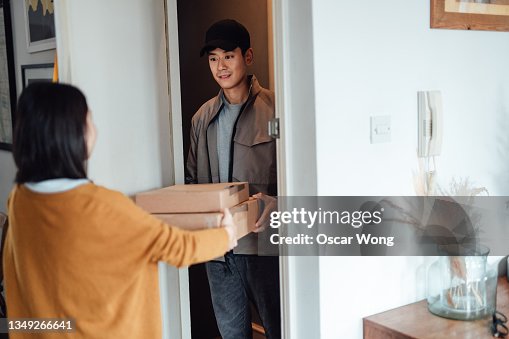 Man Giving Box Delivery Man Giving Boxes To A Young Woman High-Res Stock Photo - Getty ...