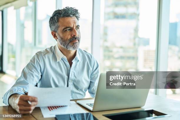 businessman with report looking away and thinking at office - pensive bildbanksfoton och bilder