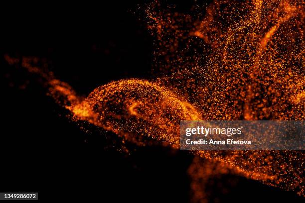 splash of many little orange particles on black background. perfect backdrop for your design - colour powder explosion stockfoto's en -beelden