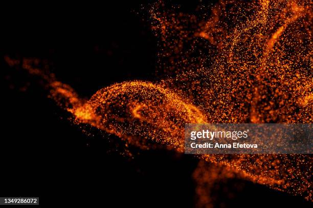 splash of many little orange particles on black background. perfect backdrop for your design - dust overlay stock pictures, royalty-free photos & images