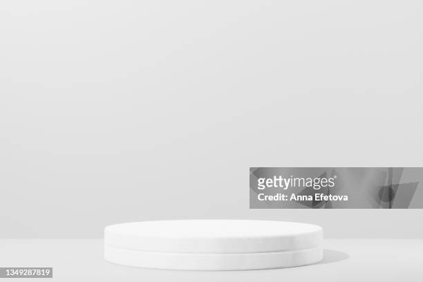 two round white ceramic podiums forming a cylinder on white background. perfect platform for showing your products. three dimensional illustration - escenario fotografías e imágenes de stock