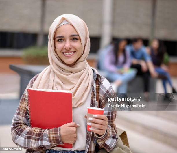 happy female muslim student smiling in college - student visa stockfoto's en -beelden