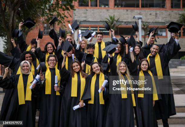 students on their graduation ready to throw their mortar boards in the air - diverse graduation stock pictures, royalty-free photos & images