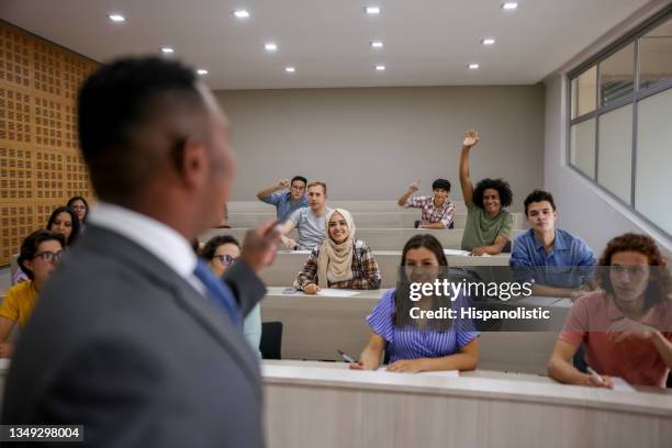 student asking a question to the teacher in class - auditoria stockfoto's en -beelden