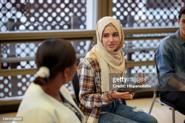 muslim college students talking to a group in counseling - mental health support stockfoto's en -beelden