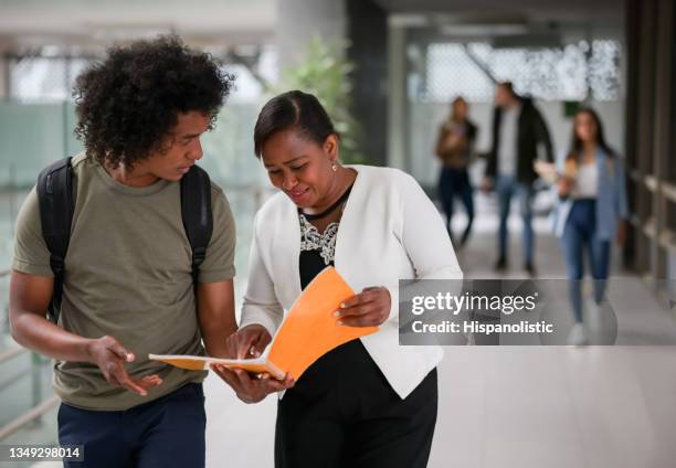 lehrer spricht mit einem afroamerikanischen college-studenten an der schule - professor stock-fotos und bilder