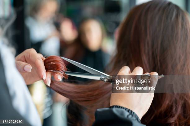 feche acima de cabeleireiro irreconhecível cortando um cabelo de clientes femininos - cortando atividade - fotografias e filmes do acervo