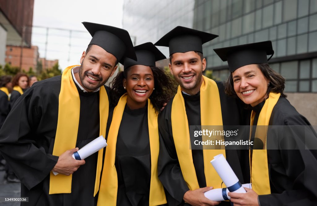 Happy group of post graduate students smiling on their graduation