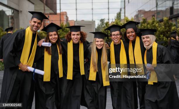 multiracial group of graduate students holding their diplomas and smiling - graduation group stock pictures, royalty-free photos & images