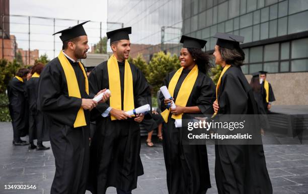 happy group of post graduate students talking after the graduation ceremony - diverse graduation stock pictures, royalty-free photos & images