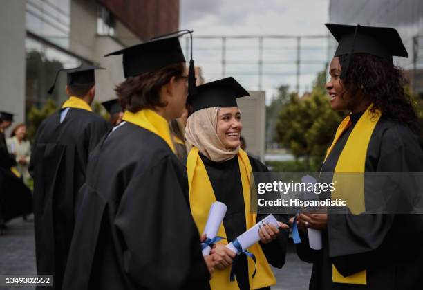 multirassische gruppe von doktoranden im gespräch nach ihrer abschlussfeier - university students celebrate their graduation stock-fotos und bilder