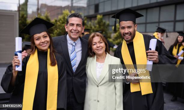 graduate students smiling with their parents on their graduation day - son graduation stock pictures, royalty-free photos & images