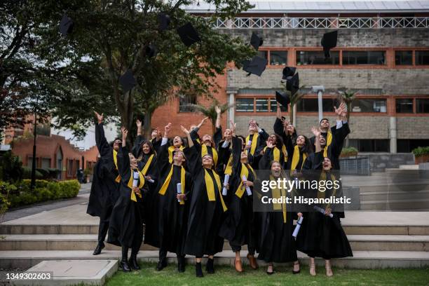 group of graduates throwing their mortarboards in the air - finale celebration stock pictures, royalty-free photos & images