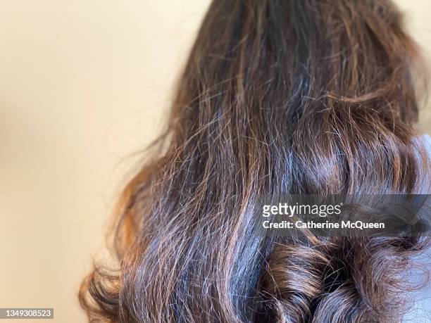 mixed-race female after a visit to salon for hair highlights treatment - black hair texture stock pictures, royalty-free photos & images