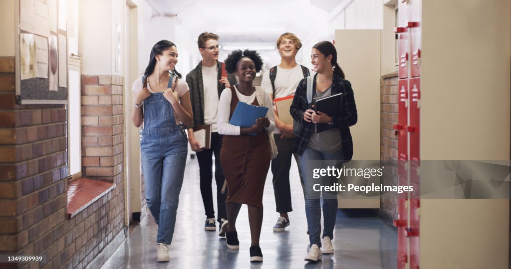 Shot of a group of teenagers walking down the hall at high school