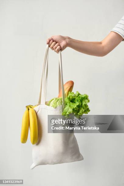 woman's hand with eco bag and vegetables. - taschen stock-fotos und bilder
