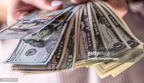 dollars banknotes in the hands of the housewife. - saldi fotografías e imágenes de stock