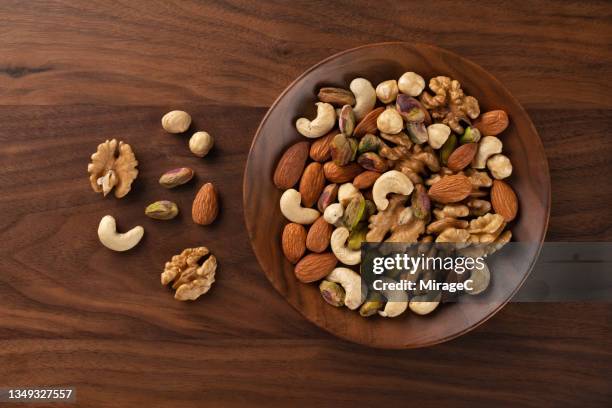 mixed nuts assortment in a wood bowl - walnut fotografías e imágenes de stock