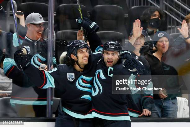 Brandon Tanev of the Seattle Kraken celebrates his goal with Mark Giordano during the second period against the Montreal Canadiens at Climate Pledge...